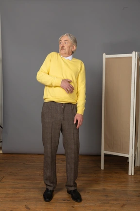 Front view of an old scared man leaning back