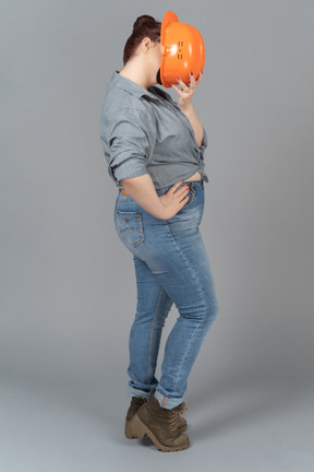 Woman closing her face with safety helmet