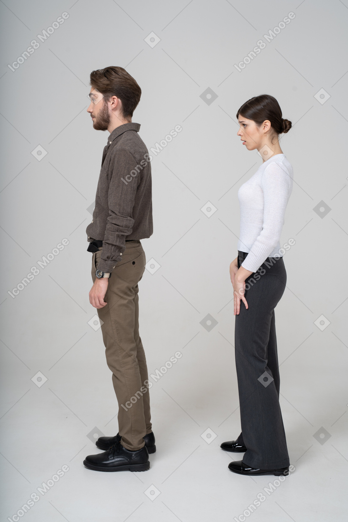 オフィス服で質問している若いカップルの側面図