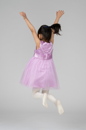 Chica con vestido rosa saltando