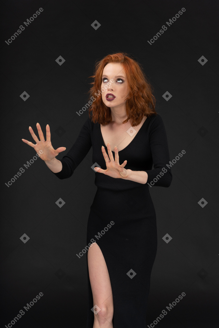 A sexy young girl dressed in black posing on the dark background