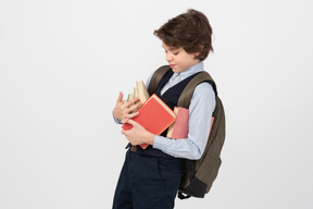 Schoolboy carrying a bunch of books