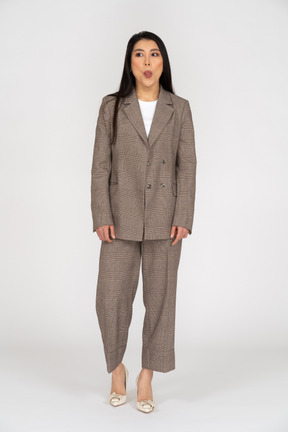 Front view of a pouting young lady in brown business suit showing tongue