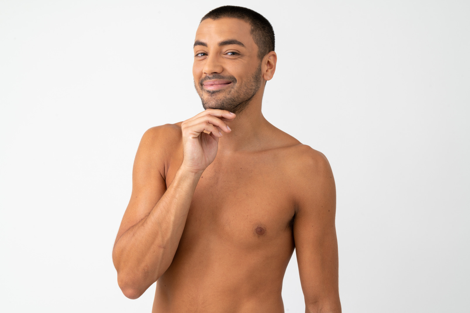 Barechested man slightly smiling and touching his chin with a hand