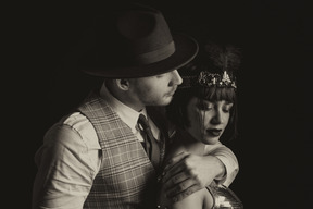 Man in hat holding a beautiful flapper from behind