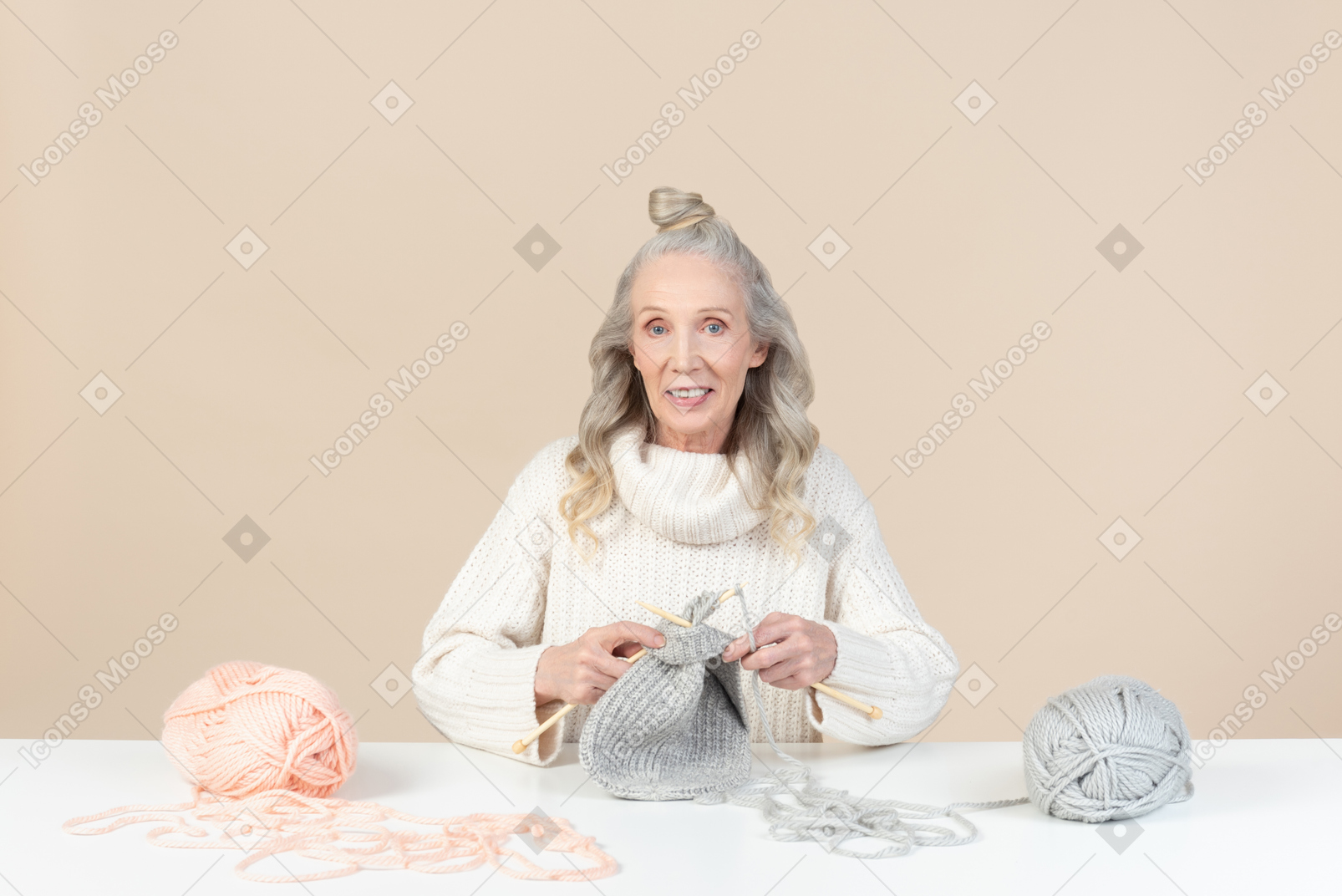 Old woman sitting at the table and knitting