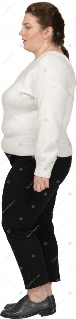 프로필에 서있는 흰색 스웨터에 자신감 더하기 크기 여자