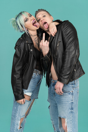 Casal punk fazendo gesto rude e mostrando as línguas