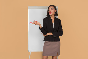 Jolie femme afro debout près du tableau blanc