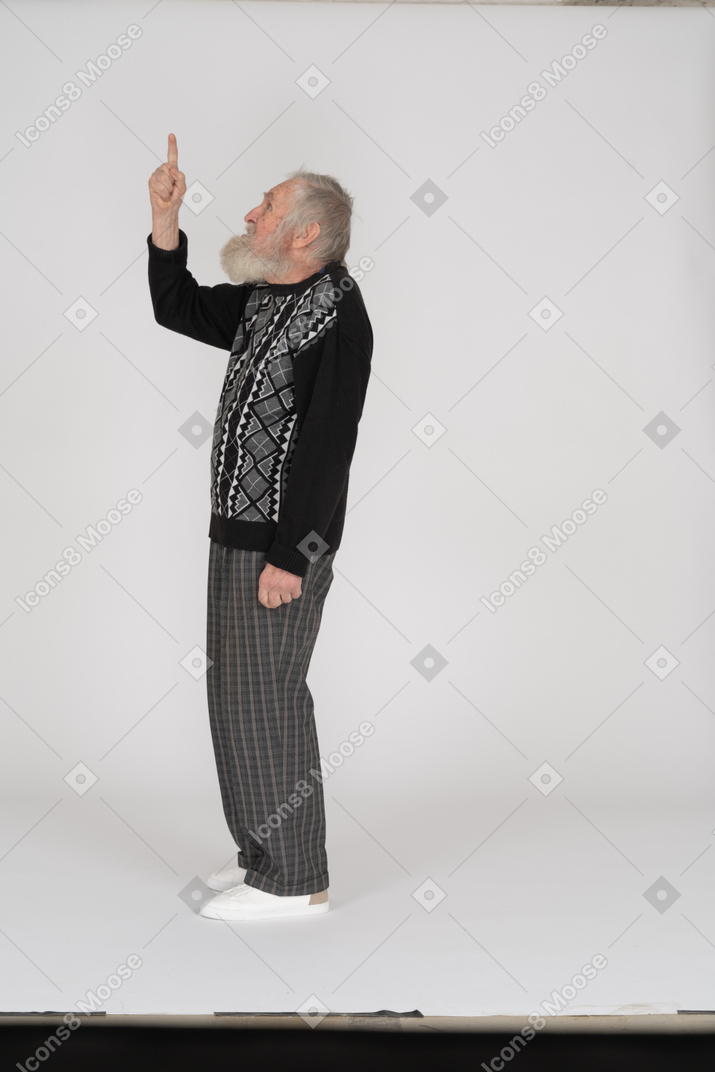 Vue latérale d'un homme âgé pointant vers le haut