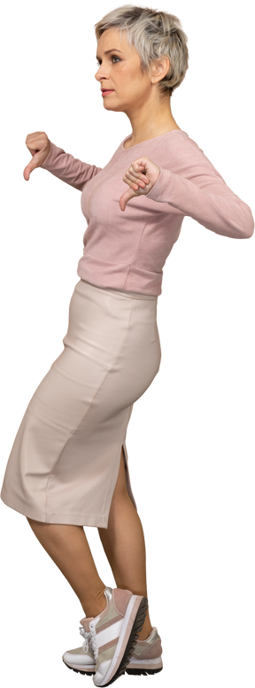 Vista lateral de uma mulher com roupas casuais mostrando os polegares para baixo