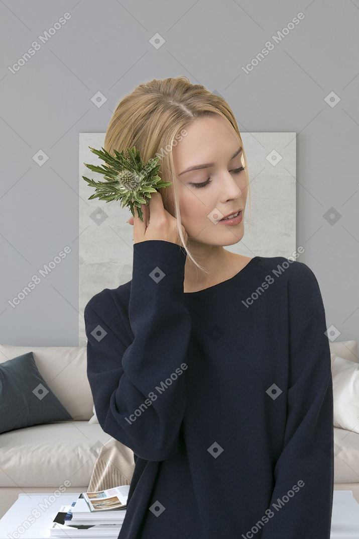 A young woman is sitting at a desk in front of a desk with a plant