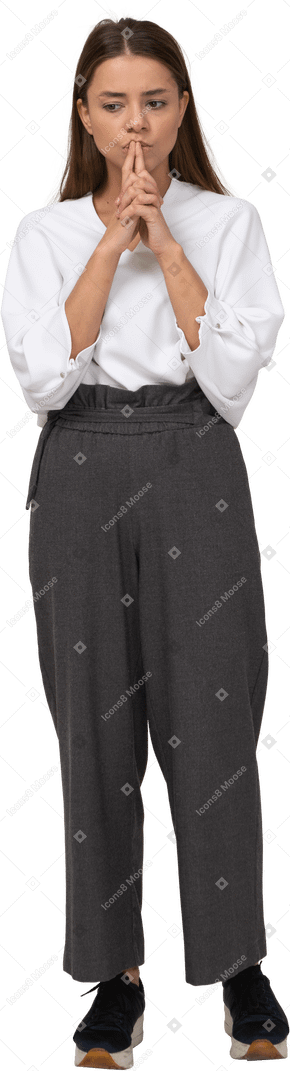Vista frontal de uma jovem pensativa com roupa de escritório, de mãos dadas