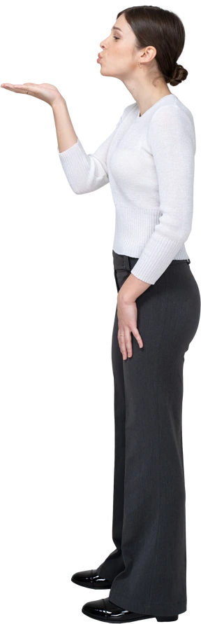 Side view of a young woman in office clothing sending an air kiss