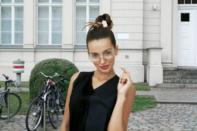 A woman in a black dress posing in front of a building