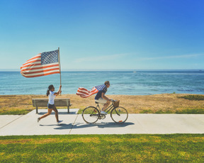 People running and riding a bike with american flags