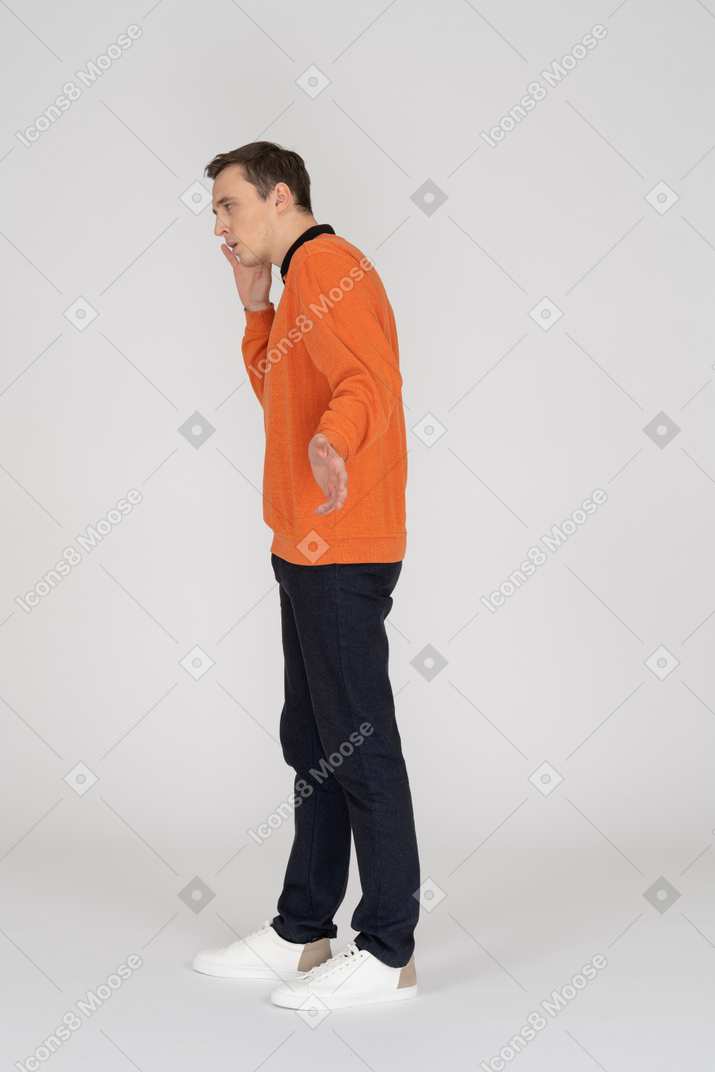 Young man in orange sweatshirt standing