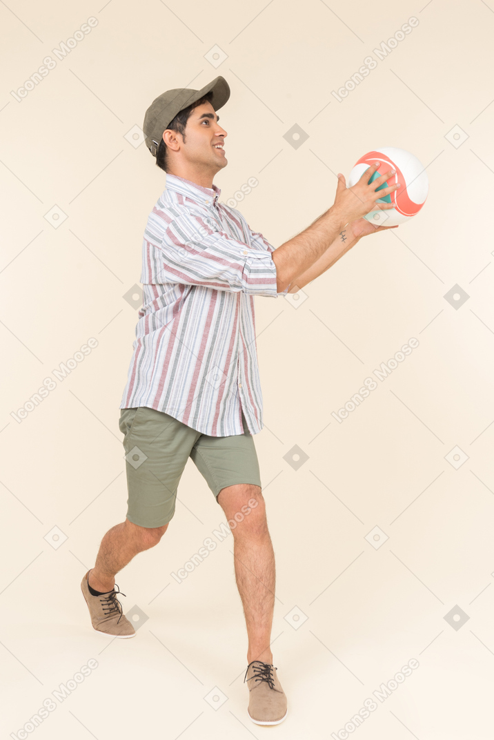 Young caucasian guy holding ball