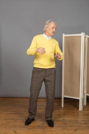 Front view of a gesticulating old man looking aside