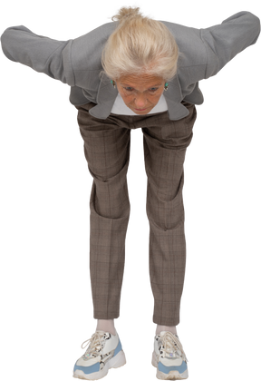 Front view of an old lady in suit bending down