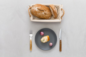 Piece of bread, cutlery  and garlic bread