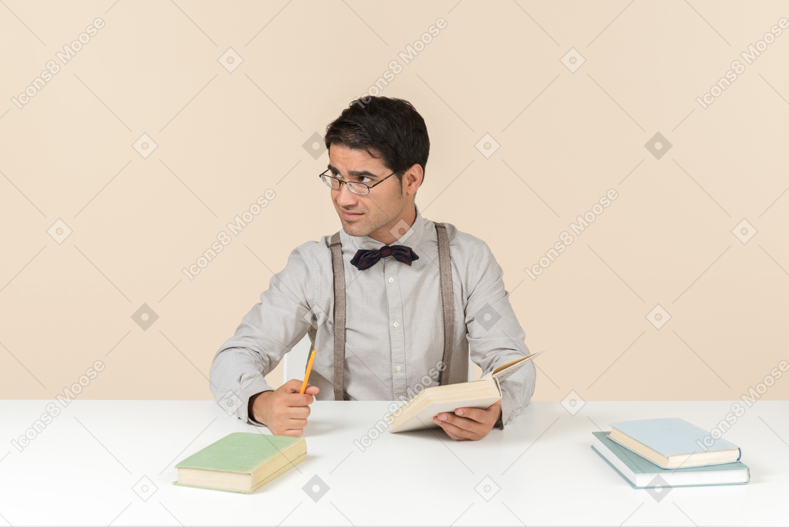 Professore seduto al tavolo a leggere libri