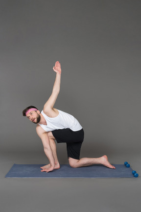 A man doing a yoga pose on a blue mat