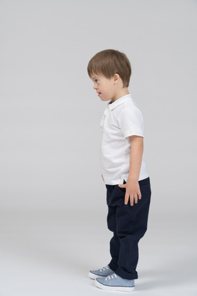 Side view of little boy standing with arms at side