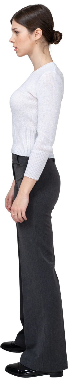 Side view of a young woman in office clothing standing still