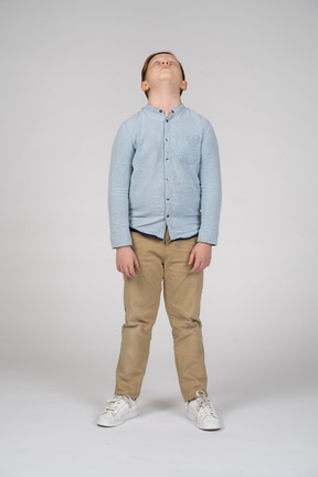 見上げるカジュアルな服装の少年の正面図