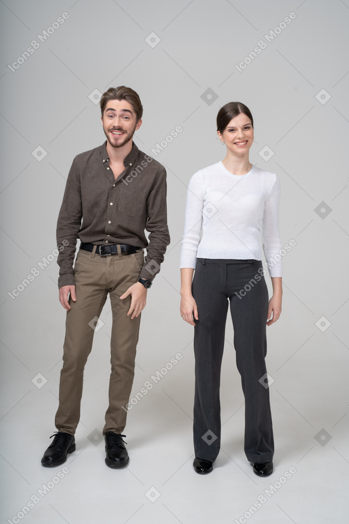 オフィス服で笑っている若いカップルの正面図