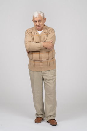 一位身穿休闲服、双臂交叉站立的老人的正面图
