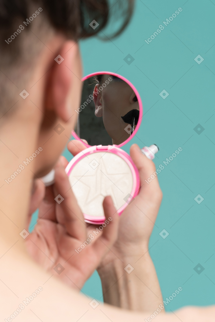 Close-up of a person applying lipstick