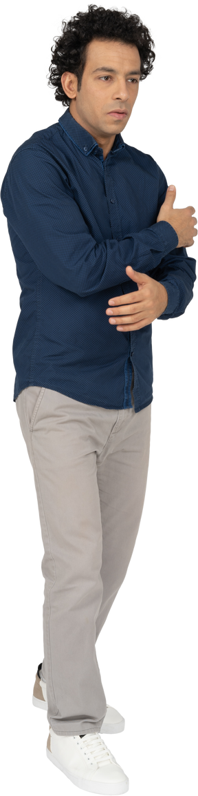 Front view of a man in casual clothes hugging himself