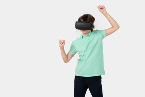 Garoto com fone de ouvido de realidade virtual segurando algo invisível em seu mundo virtual