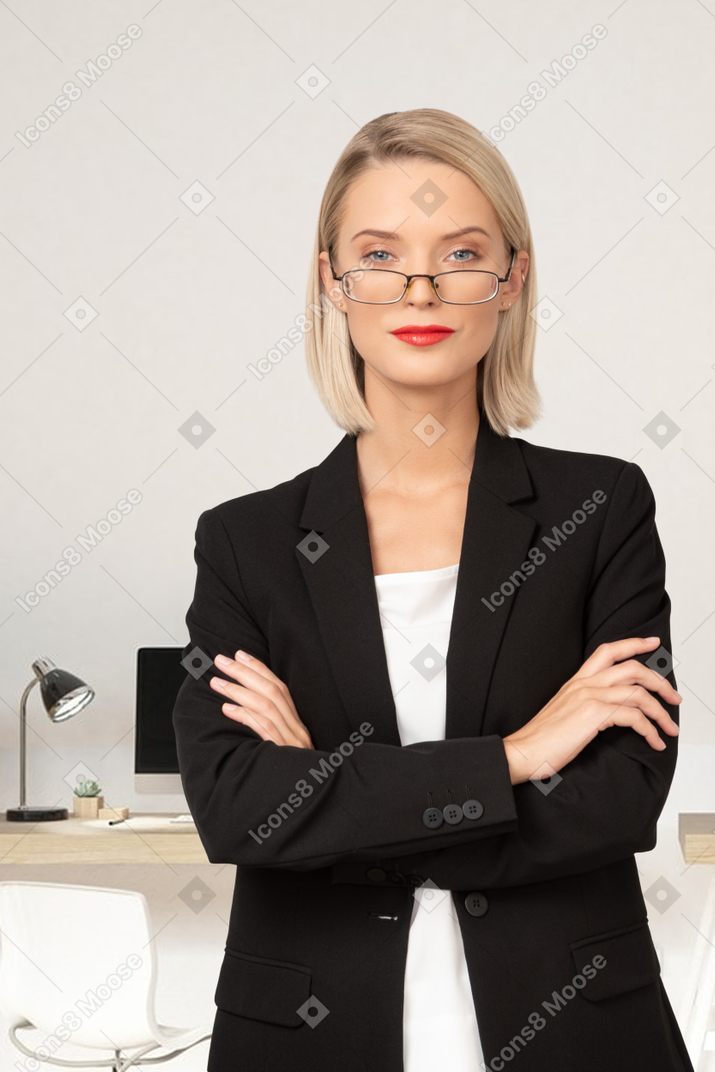 A woman in a business suit with her arms crossed