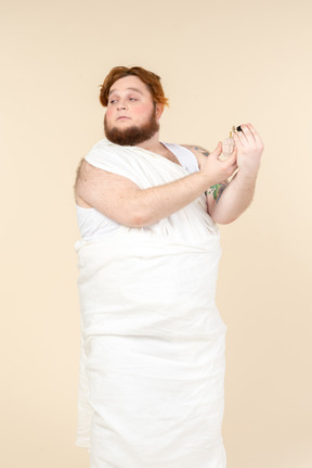 Big guy wrapped in towel applying perfume