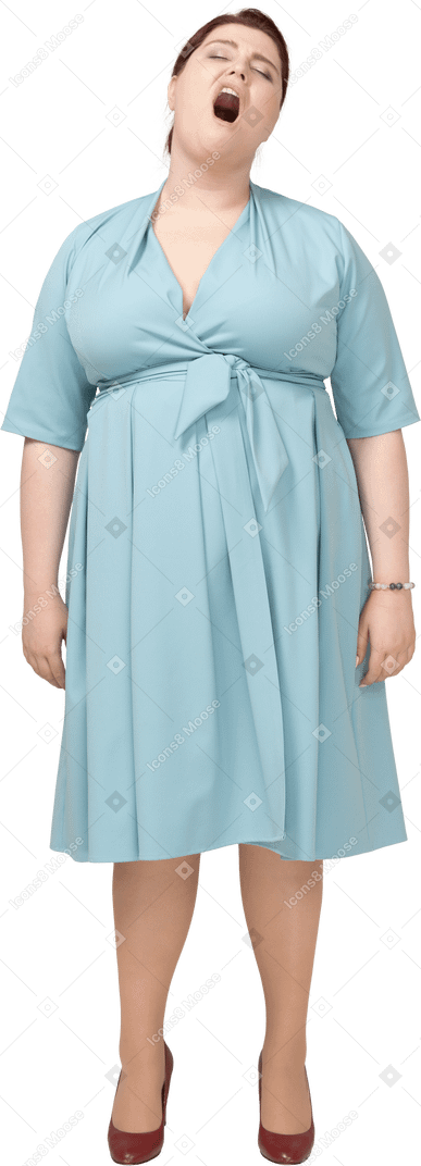 Vista frontale di una donna in abito blu che sbadiglia