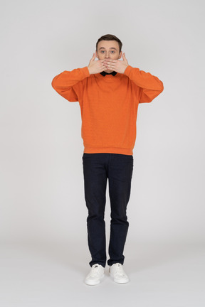 Junger mann im orangefarbenen sweatshirt stehend