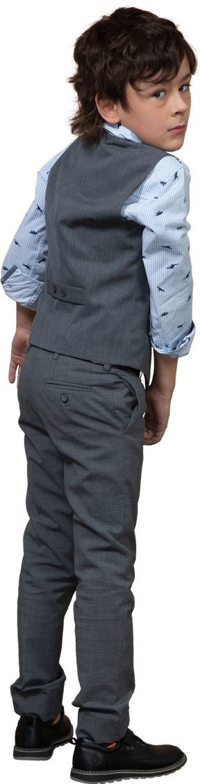 Rear view of a boy in grey suit looking at camera
