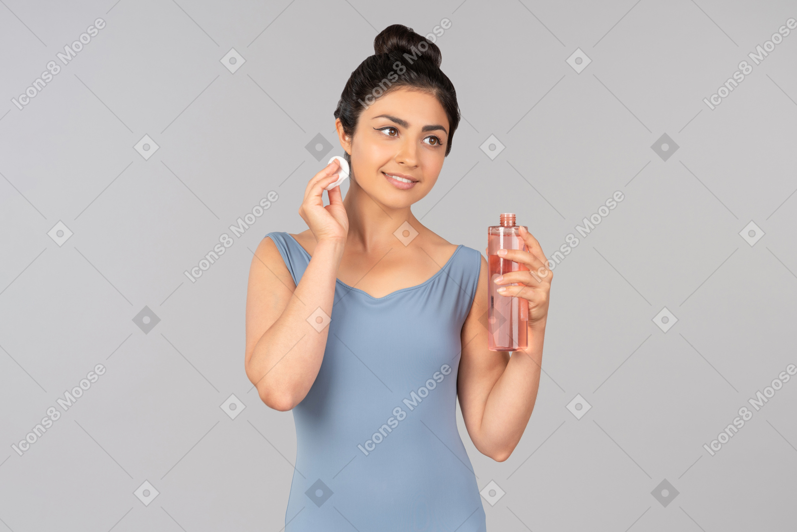 Young indian woman applying face cleaning product