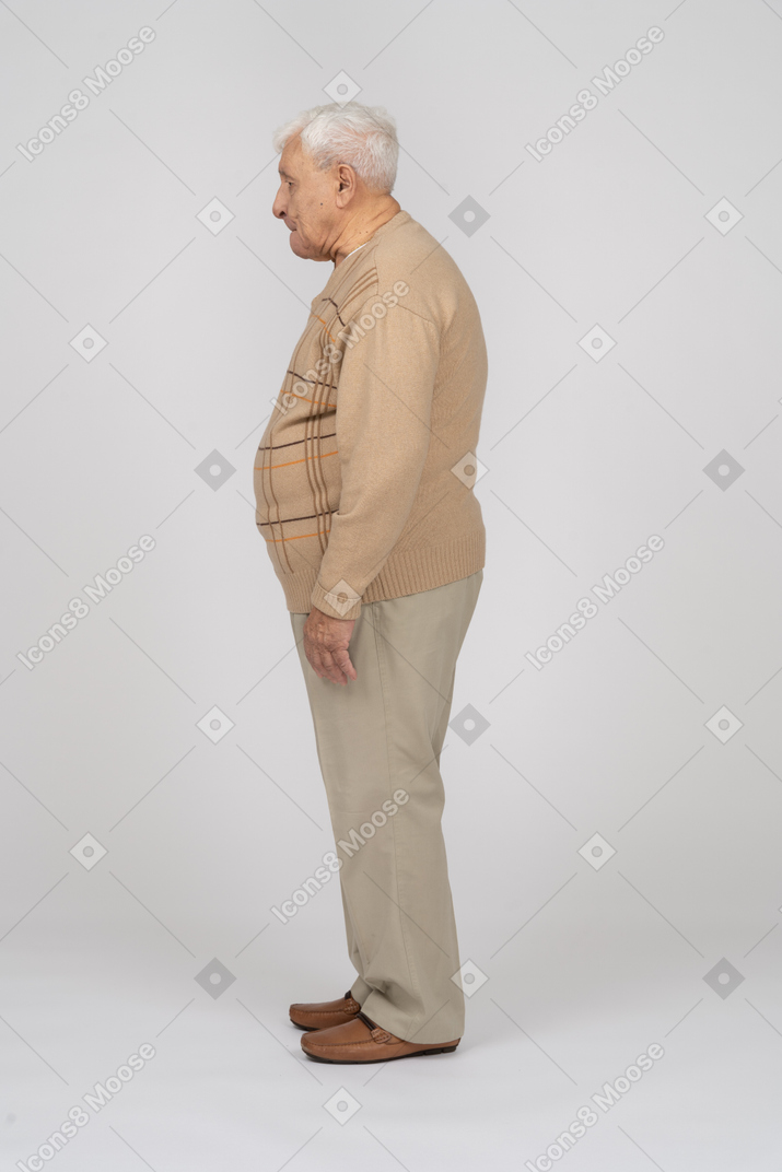 Vecchio in abiti casual in piedi di profilo