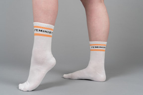 Female feet in socks on gray background