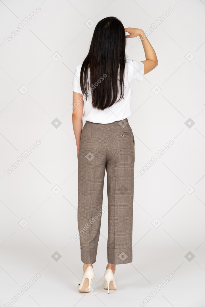 Vista traseira de uma jovem de calça procurando por algo