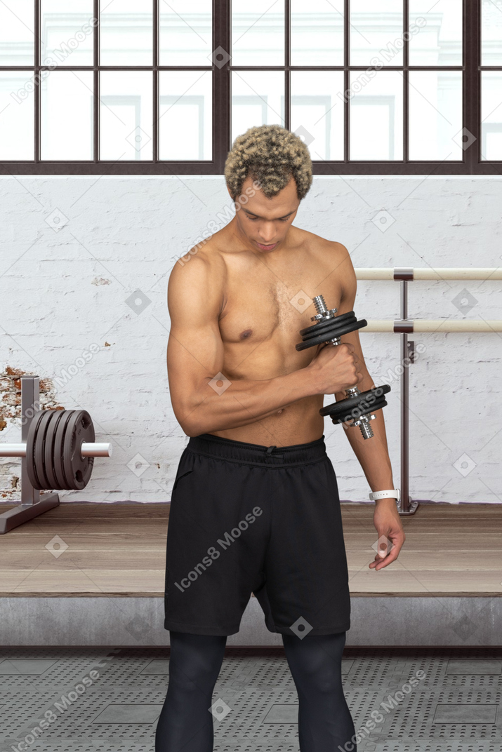 A topless sportsman holding a dumbbell