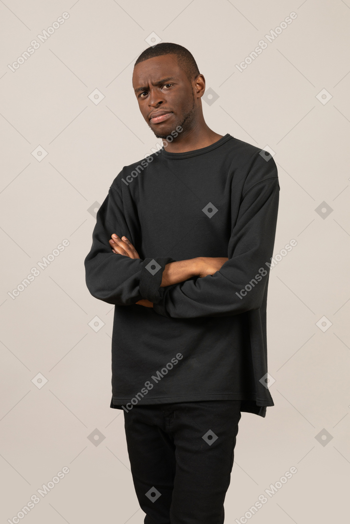 Man with arms crossed frowning