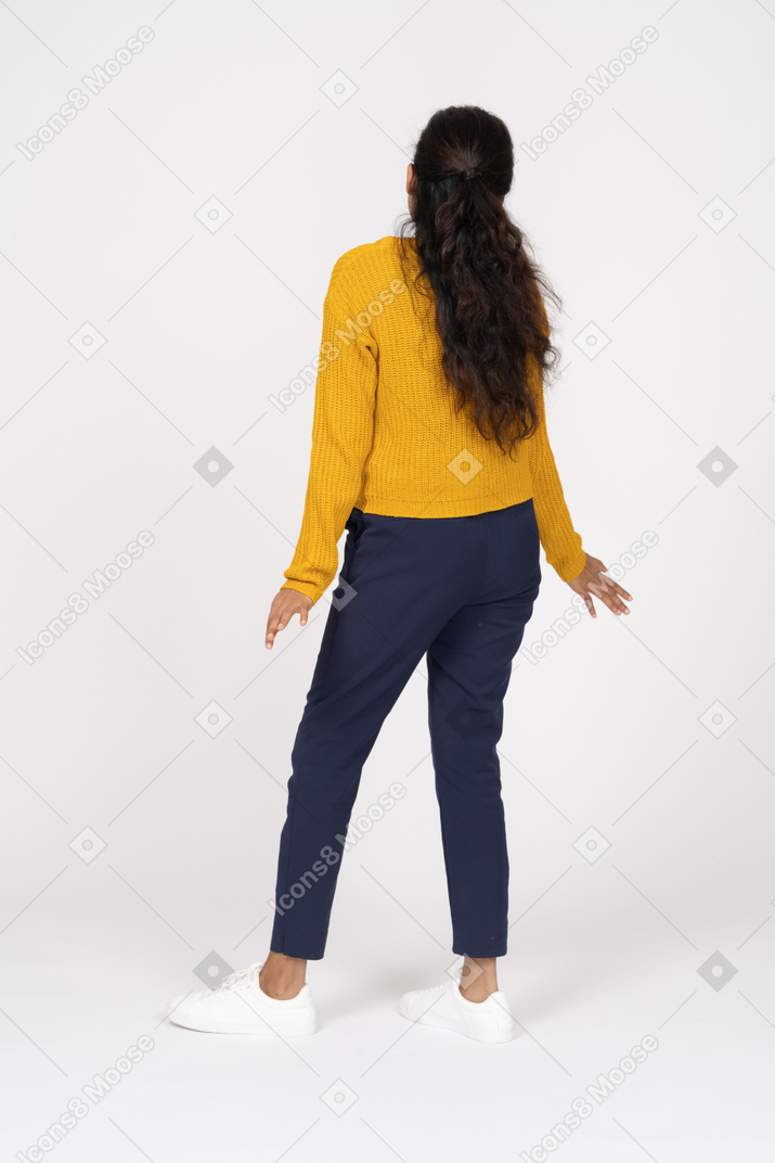 Вид сзади девушки в повседневной одежде, стоящей с протянутыми руками