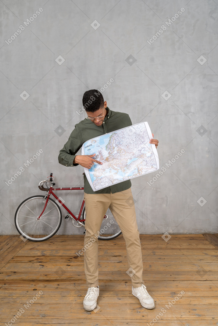 Vista frontale di un uomo che guarda e indica una mappa