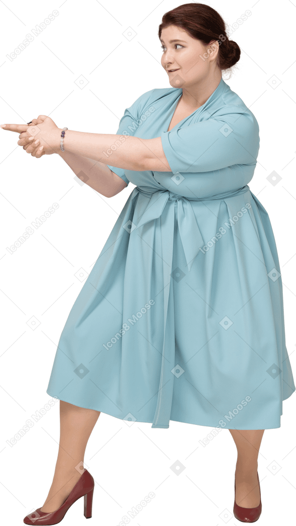 Вид сбоку женщины в синем платье показывает пистолет с пальцами