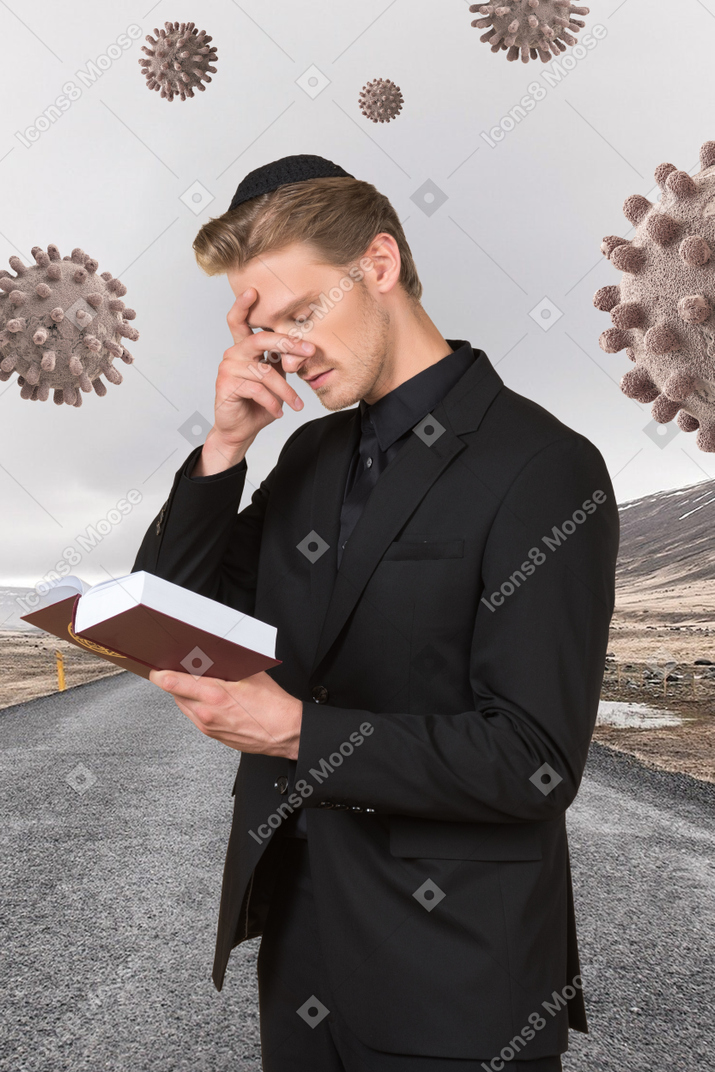 Priest surrounded by coronavirus molecules reading the bible